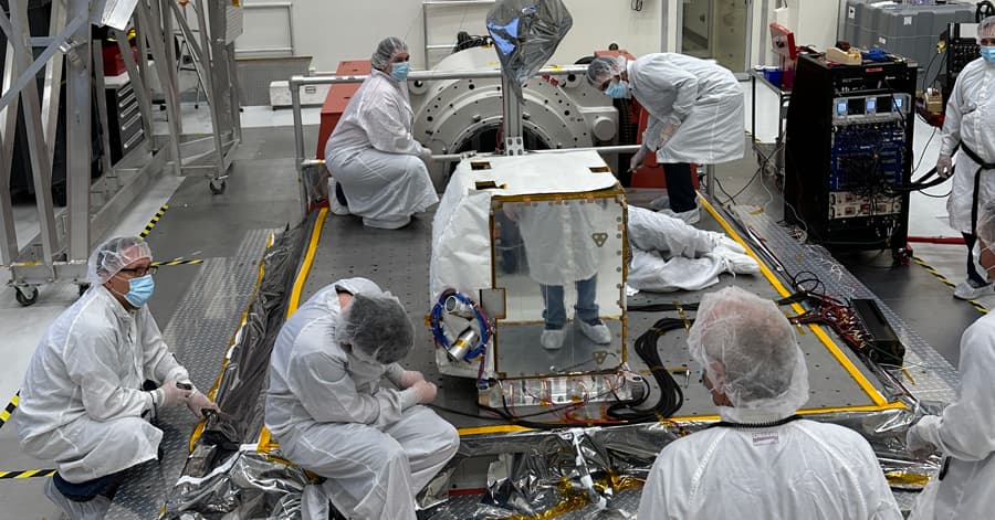 Group of scientists working on a satellite