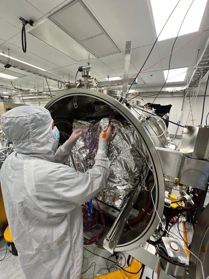 An engineer prepares the imaging spectrometer instrument for testing in a thermal vacuum chamber at JPL. Image Credit: NASA/JPL-Caltech