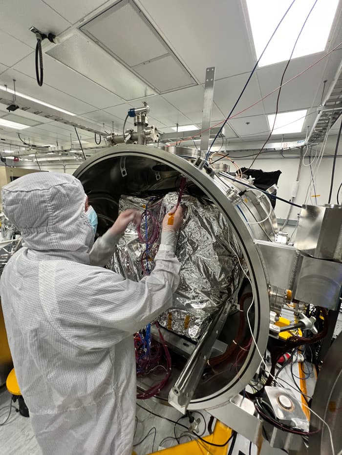 An engineer prepares the imaging spectrometer instrument for testing in a thermal vacuum chamber at JPL. Image Credit: NASA/JPL-Caltech