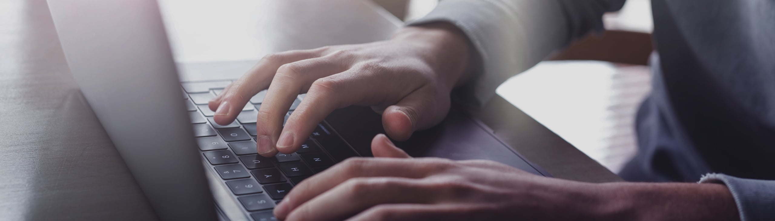 Closeup of hands typing on a laptop