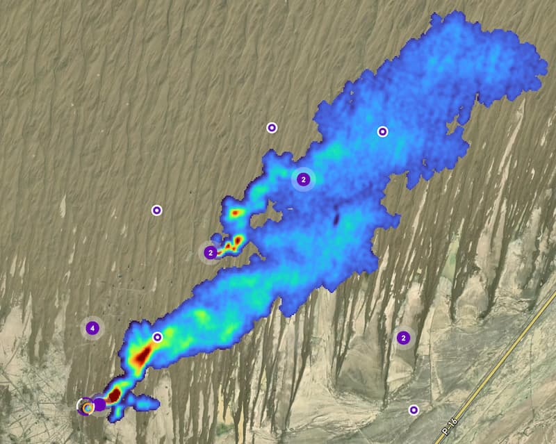 Two methane plumes from the Carbon Mapper data portal are pictured against a satellite background. They are a blue to red gradient color, which is based on the emissions rate.