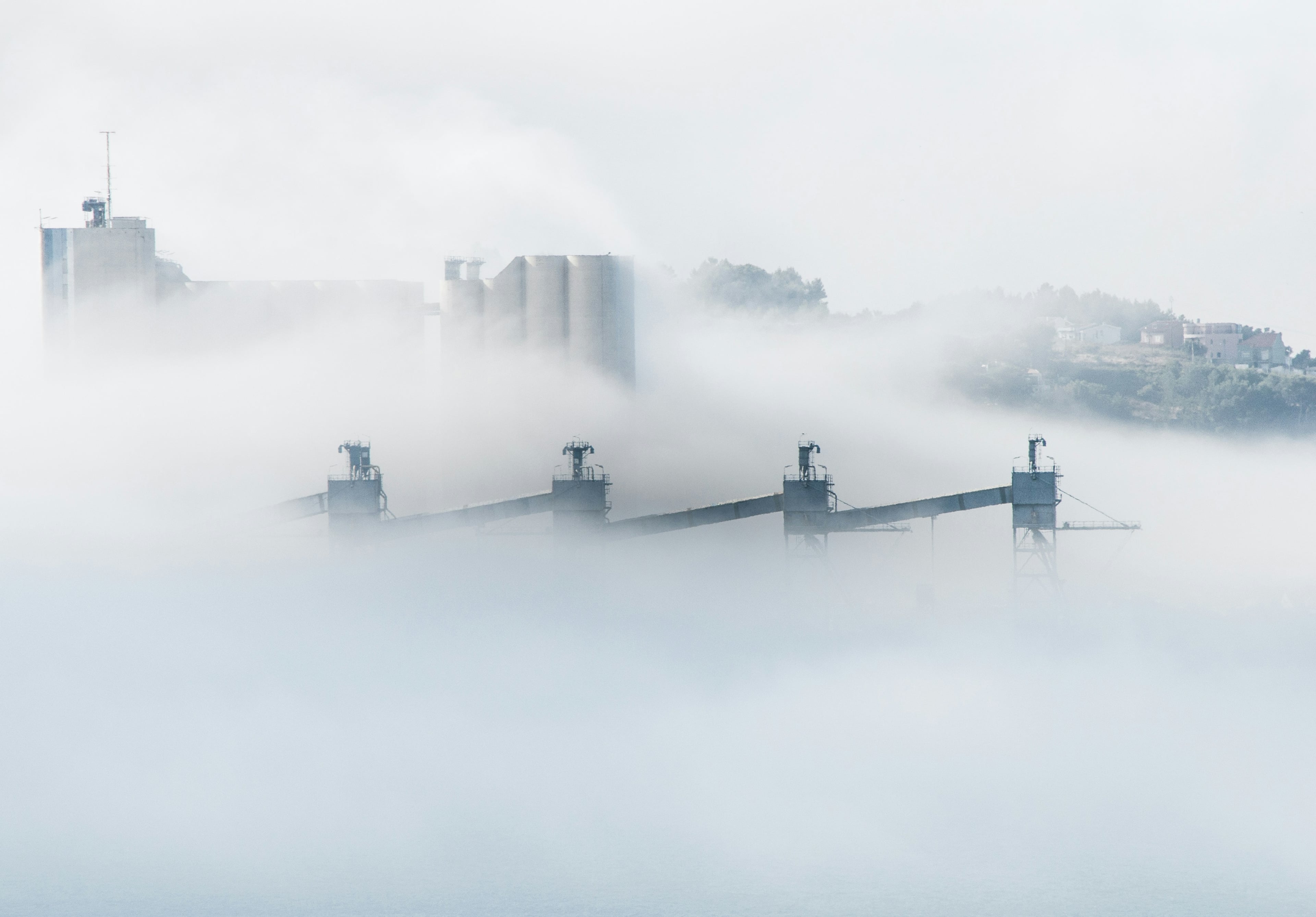 Image of white smoke outside of an industrial complex