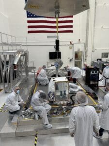 NASA JPL scientists and workers observe the instrument in the lab.